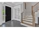 Bright foyer with elegant staircase, black front door and french doors leading to another room at 2432 Spindle Ct, Raleigh, NC 27603