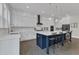 Kitchen island with seating and pendant lights, custom cabinets, and a view of the backyard at 2432 Spindle Ct, Raleigh, NC 27603