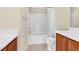 Bright bathroom features a tub/shower combo with white tile and a double sink vanity at 2604 Wyntercrest Ln, Durham, NC 27713