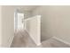 Neutral hallway showcasing plush carpet, half wall and access to other rooms at 2604 Wyntercrest Ln, Durham, NC 27713