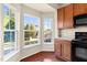 Kitchen with a bay window, wood cabinets and black appliances at 2604 Wyntercrest Ln, Durham, NC 27713