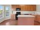 Kitchen with wood cabinets, white countertops and black appliances at 2604 Wyntercrest Ln, Durham, NC 27713