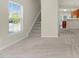 Bright living room with staircase access, window, and entry to the kitchen area at 2604 Wyntercrest Ln, Durham, NC 27713