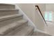 Carpeted staircase with wooden banister leading to the upper level of the home at 2604 Wyntercrest Ln, Durham, NC 27713