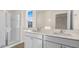 Bathroom featuring double sinks with white cabinetry, large mirror, and a glass-enclosed shower at 270 Palm Dr, Sanford, NC 27330