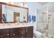 Bathroom with a double sink vanity, large mirror, glass-enclosed shower, and neutral tile at 2814 Sarah Ave, Durham, NC 27707