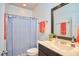 Well-lit bathroom featuring a vanity, toilet, and a shower with a blue patterned curtain at 2814 Sarah Ave, Durham, NC 27707