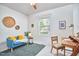 Inviting bedroom with a blue loveseat, wooden desk, and natural light streaming through the window at 2814 Sarah Ave, Durham, NC 27707