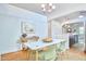 Bright dining room with a modern white table, light green chairs, and a stylish chandelier at 2814 Sarah Ave, Durham, NC 27707