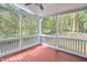 Comfortable screened porch area with outdoor view, ceiling fan, and painted wood railings at 2814 Sarah Ave, Durham, NC 27707