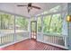 Inviting screened porch with ceiling fan, wood floor, and view of private wooded backyard at 2814 Sarah Ave, Durham, NC 27707