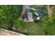 Aerial shot of a house situated on a lot surrounded by trees, with a shed, fire pit, and neighboring houses nearby at 2824 Wyncote Drive, Raleigh, NC 27603