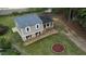 An aerial view of a home with gray siding, a fire pit, a shed, and a spacious lawn surrounded by mature trees at 2824 Wyncote Drive, Raleigh, NC 27603