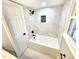 Well-lit bathtub and shower combo with modern white tile and contrasting dark fixtures, creating a comfortable space at 2824 Wyncote Drive, Raleigh, NC 27603