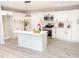 Modern kitchen featuring white cabinets, stainless steel appliances, island with sink, and stylish pendant lighting at 2824 Wyncote Drive, Raleigh, NC 27603