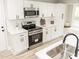 Well-equipped kitchen with stainless steel appliances, white cabinets, white countertops, and stylish hardware at 2824 Wyncote Drive, Raleigh, NC 27603