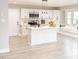 Modern kitchen featuring white cabinets, stainless steel appliances, island with sink, and a cozy window seat at 2824 Wyncote Drive, Raleigh, NC 27603