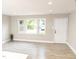 Bright living room with hardwood floors, a large window, white trim and a white door at 2824 Wyncote Drive, Raleigh, NC 27603