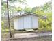 An outdoor shed featuring double doors, wood ramp access, and a small surrounding yard space at 2824 Wyncote Drive, Raleigh, NC 27603