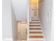 A stairway leads to an open door with modern wooden steps and white risers, offering a bright and inviting transition at 2824 Wyncote Drive, Raleigh, NC 27603