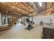 Unfinished basement features exposed ceiling beams, concrete floors, and a staircase to the main level at 2931 Western Hills Ln, Elon, NC 27244