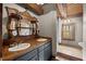 Charming bathroom featuring wood accents, double sinks, and a shower with window at 2931 Western Hills Ln, Elon, NC 27244