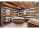 Bathroom with rustic charm, showcasing a stone-encased tub, wood floors, and log walls at 2931 Western Hills Ln, Elon, NC 27244