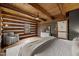 Rustic bedroom featuring exposed wood beams, log walls, and cozy armchair with natural light at 2931 Western Hills Ln, Elon, NC 27244