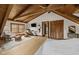 Spacious bedroom with wood floors, beamed ceilings, comfortable seating, and access to ensuite bath at 2931 Western Hills Ln, Elon, NC 27244