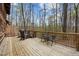 Outdoor wooden deck with seating, a grill, and scenic views of the surrounding trees at 2931 Western Hills Ln, Elon, NC 27244