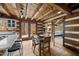 Rustic dining area with exposed beams, a wooden table, and access to a screened porch at 2931 Western Hills Ln, Elon, NC 27244