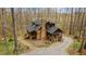 A beautiful log home nestled in the woods with a stone chimney and inviting porches at 2931 Western Hills Ln, Elon, NC 27244