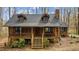 Charming log cabin featuring a stone foundation, cozy porch, and rustic charm at 2931 Western Hills Ln, Elon, NC 27244