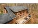 Aerial view of a log home with a deck, grill, and outdoor seating, offering a private wooded retreat at 2931 Western Hills Ln, Elon, NC 27244