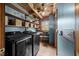 A well-lit laundry room with modern washer and dryer, wood beam and open shelving at 2931 Western Hills Ln, Elon, NC 27244