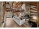 A spacious living room with a stone fireplace, wood beams, and a view of the kitchen at 2931 Western Hills Ln, Elon, NC 27244