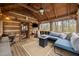 Covered porch featuring wood ceiling, bench seating, gas fireplace, and views of the woods at 2931 Western Hills Ln, Elon, NC 27244