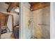 Shower with stone tiles and rustic charm, accented by wood beams and a hand-held wand at 2931 Western Hills Ln, Elon, NC 27244