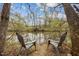 Scenic water view featuring two chairs and a beautiful wooded backdrop, perfect for relaxing outdoors at 2931 Western Hills Ln, Elon, NC 27244
