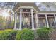 Inviting covered back porch with dark wood ceiling and beams, and outdoor seating for relaxing and entertaining at 3016 Allansford Ln, Raleigh, NC 27613