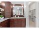 Bathroom with a dark wood vanity with granite countertop, mirror, and walk-in closet at 3016 Allansford Ln, Raleigh, NC 27613