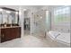 Bright bathroom features a glass enclosed shower, soaking tub, stained glass window, and granite countertop vanity at 3016 Allansford Ln, Raleigh, NC 27613