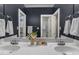 Elegant bathroom featuring double sinks with chrome fixtures, a large mirror, and dark blue walls at 3016 Allansford Ln, Raleigh, NC 27613
