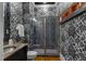 Modern bathroom featuring dark cabinets, glass enclosed shower and bold wallpaper at 3016 Allansford Ln, Raleigh, NC 27613