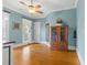Light blue bedroom with hardwood floors, ceiling fan and view through large window at 3016 Allansford Ln, Raleigh, NC 27613