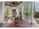 Relaxing covered deck featuring a stone fireplace, outdoor seating, and scenic wooded views at 3016 Allansford Ln, Raleigh, NC 27613