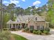 Gorgeous brick home with covered porch, complemented by mature trees and manicured landscaping at 3016 Allansford Ln, Raleigh, NC 27613