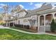 Charming home exterior featuring a covered porch, well-manicured lawn and an attached garage with dark wood doors at 3016 Allansford Ln, Raleigh, NC 27613