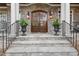 Elegant entryway with stone steps leading to a double wooden door and decorative planters at 3016 Allansford Ln, Raleigh, NC 27613