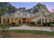 Elegant front exterior of a brick home with manicured landscaping, a stone porch, and double front doors at 3016 Allansford Ln, Raleigh, NC 27613